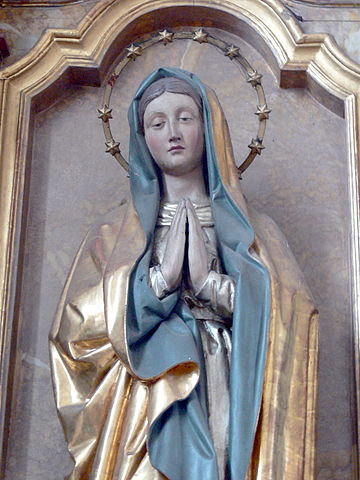 Statue of Mary with 12-star halo, wearing a blue-lined robe.