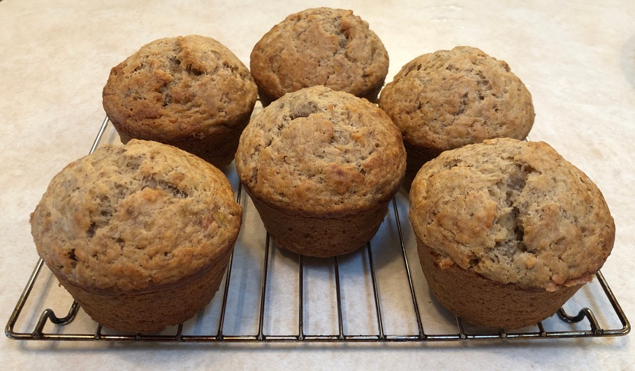 Photograph of 6 large muffins, cooling on a rack.