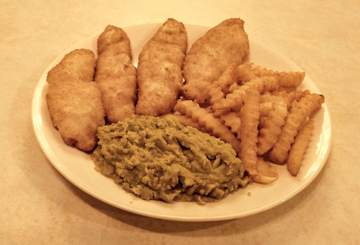 Photograph of mushy peas on plate, with fish and chips.